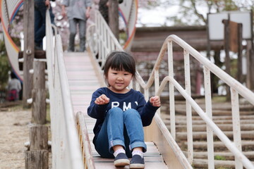 Fototapeta na wymiar 公園の滑り台で遊ぶ女の子