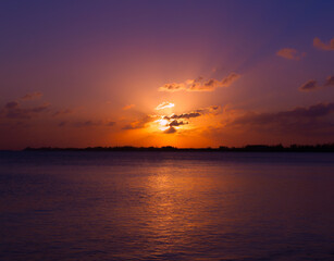 Beautiful over the sea golden blue orange tropical sunset reflected in sea