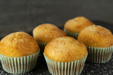 Set of delicious freshly baked cupcakes with sugar on top on a background