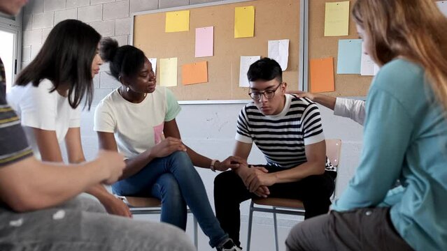 Group of multiracial teen students support, comfort hispanic teen male classmate having bad day. Mental health. Video 4k
