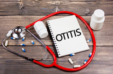 Otitis diagnosis concept.The word otitis on paper next to the stethoscope on the table.