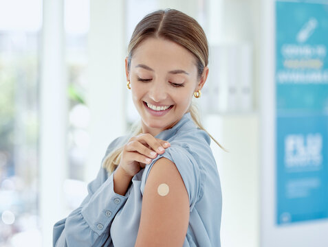 Covid, vaccine and plaster with a healthcare woman in a hospital after getting a shot, booster or medical injection. Injection, immunity and medicine with a female getting vaccinated in a clinic