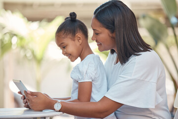 Mother, girl and tablet streaming cartoon, video or education game for children while sitting outdoor. Latin woman and her young daughter watching funny children movie online with technology