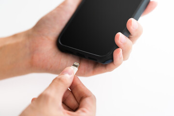 スマートフォンを充電する女性の手