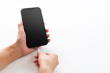スマートフォンを充電する女性の手