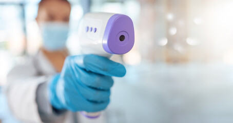 Covid, nurse hand and health thermometer scan check at a hospital, healthcare or clinic from a doctor. Woman working with medical temperature measure to see fever for disease, dengue fever or corona