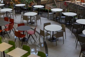 Fototapeta na wymiar Empty tables and comfortable seating at a food court in a shopping mall.