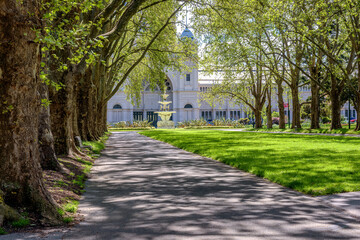 A row of trees leading to a fountain in front of the Royal Exhibition Building at Carlton Gardens in Melbourne, Australia.