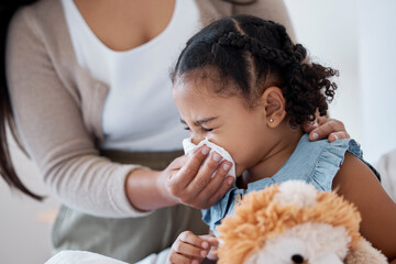 Mother clean sick child nose with tissue, playing with toy or teddy bear in bedroom at family home....