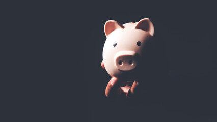 Save money, financial planning of personal finances and being thrifty concept theme with a pink piggy bank sitting on a wood table.