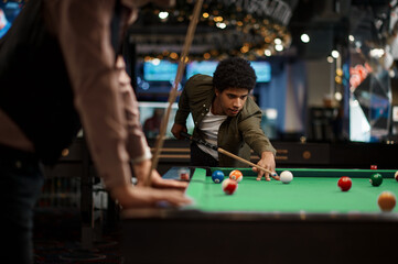 Company of handsome young guy playing in pool