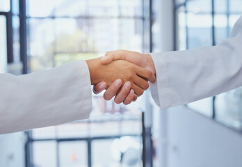 Doctors meeting, shaking hands and partner at hospital with lab coats. Scientist or doctor agree on...