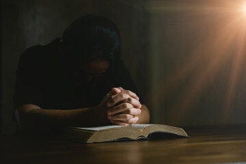 Prayer person hand in black background. Christian catholic woman are praying to god in dark at...