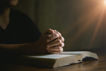 Prayer person hand in black background. Christian catholic woman are praying to god in dark at...