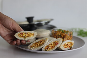 Paneer stuffed kodo millet Idly. Steamed savory cakes made of kodo millets and lentil flour stuffed with a patty made of scrambled cottage cheese with onions and tomatos