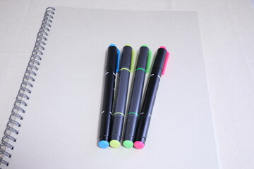 白いノートと各色のマーカーペン