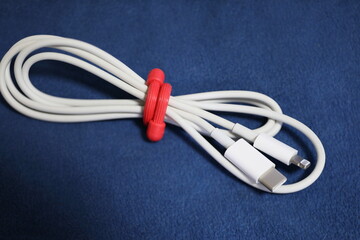 スマホの白い充電ケーブルを束ねている