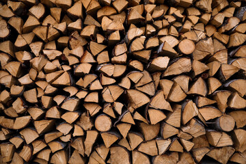 Stacked firewood as background. Heating house in winter