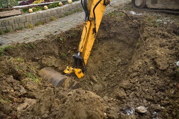 A road excavator dredges the hole near the family house  - 536686025