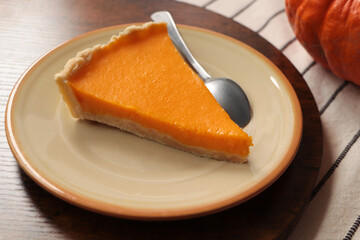 Plate with piece of fresh homemade pumpkin pie on table