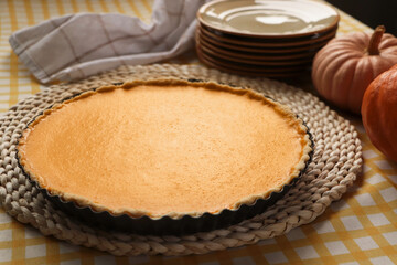 Delicious homemade pumpkin pie in baking dish on table