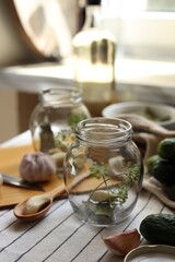 Empty glass jars and ingredients prepared for canning on table indoors