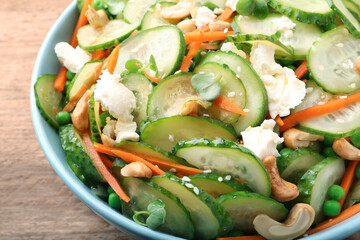 Delicious cucumber salad on wooden table, closeup