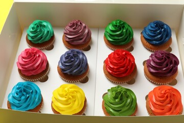 Different cupcakes with cream in box, closeup