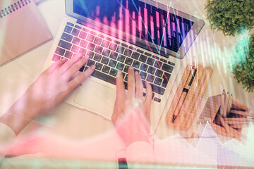 Double exposure of woman hands working on computer and forex chart hologram drawing. Top View. Financial analysis concept.