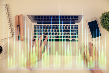 Double exposure of woman hands working on computer and forex chart hologram drawing. Top View. Financial analysis concept.