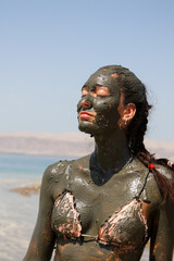 beautiful woman with body covered with dead sea beneficial mud