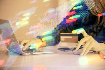 Double exposure of woman on-line shopping holding a credit card and data theme hologram drawing....