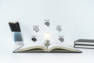 Bright lightbulb on book or textbook with brain icon. Learning or training skill course or...