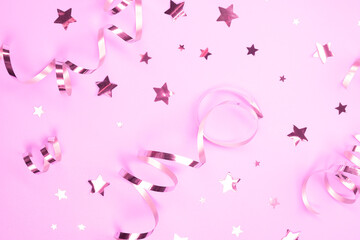 festive background with pink serpentine and confetti stars decorative, background. concept of a party or birthday party in pink colors or a newborn baby girl
