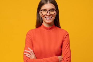 Closeup portrait of smart successful businesswoman with arms crossed isolated on yellow background