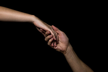 Gentle touch of female and male hands on a black background. Gesture expressing love and tenderness