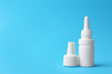 Bottle of medical drops on light blue background. Space for text