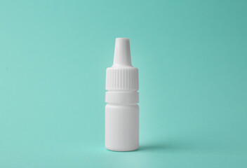 Bottle of medical drops on turquoise background