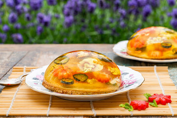 Lemon jelly globes with fresh fruit, edible flowers and gold flakes on pistachio biscuit - gourmet dessert