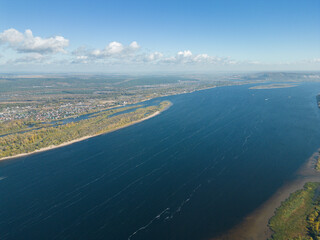 The concept of an ecological village. A combination of nature and ecology. A village on the banks of a river and mountains, a view from a drone. Aerial photography autumn. Gold autumn