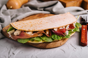 Piadina - classic Italian tortilla-bread with prosciutto, basil and dor blue