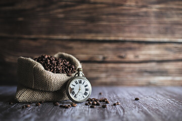 Very old watch in front of coffee jute sack