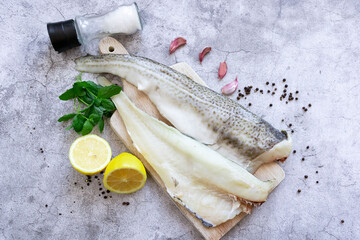 Fresh fish, raw cod fillet. Lies on a wooden board in the kitchen