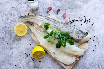 Fresh fish, raw cod fillet. Lies on a wooden board in the kitchen