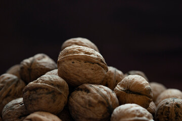Bowl full of walnuts on black background with copy space