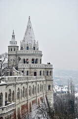 Fototapeta na wymiar Fisherman`s Bastion in Budapest, Hungary, in a cold snowy and foggy winter day
