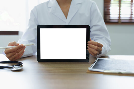 Asian female doctor holds computer tablet to customer, white screen can insert text or image