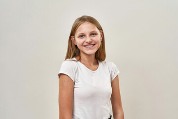 Smiling teenage girl with braces looking at camera - obrazy, fototapety, plakaty