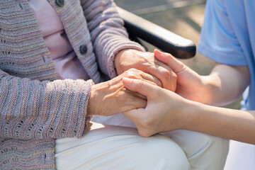 Obraz na płótnie Canvas シニア女性の手を握る介護士の手元