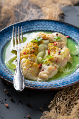 Healthy marinated herring on blue plate and fishing net.